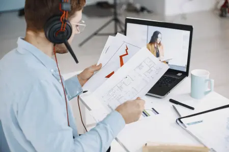 Mann mit Headset arbeitet von zu Hause aus und nutzt seinen Laptop.