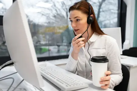 Frau im Callcenter mit Headset arbeitet am Computer und beantwortet Kundenanfragen.